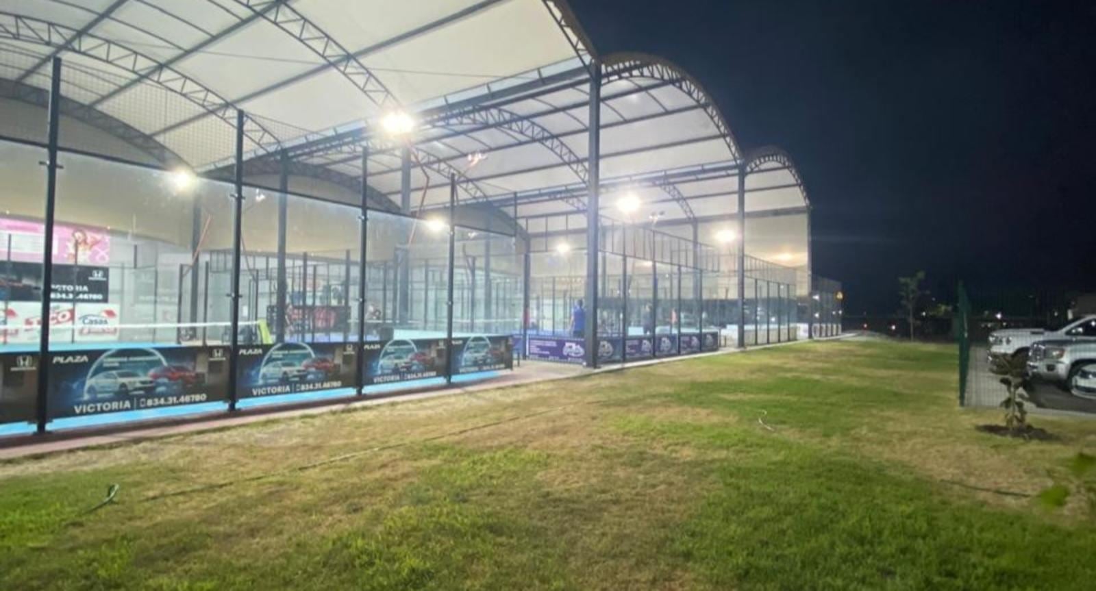 Canchas techadas de cristal del Club de Pádel Victoria iluminadas de noche